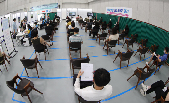 국내 코로나19 신규 확진자 수가 2052명을 기록하며 이틀째 2000명대를 기록한 20일 오전 서울 동작구 제2예방접종센터가 마련된 동작구민체육센터에서 시민들이 백신 접종 뒤 이상반응을 살피기 위해 대기하고 있다.   연합뉴스